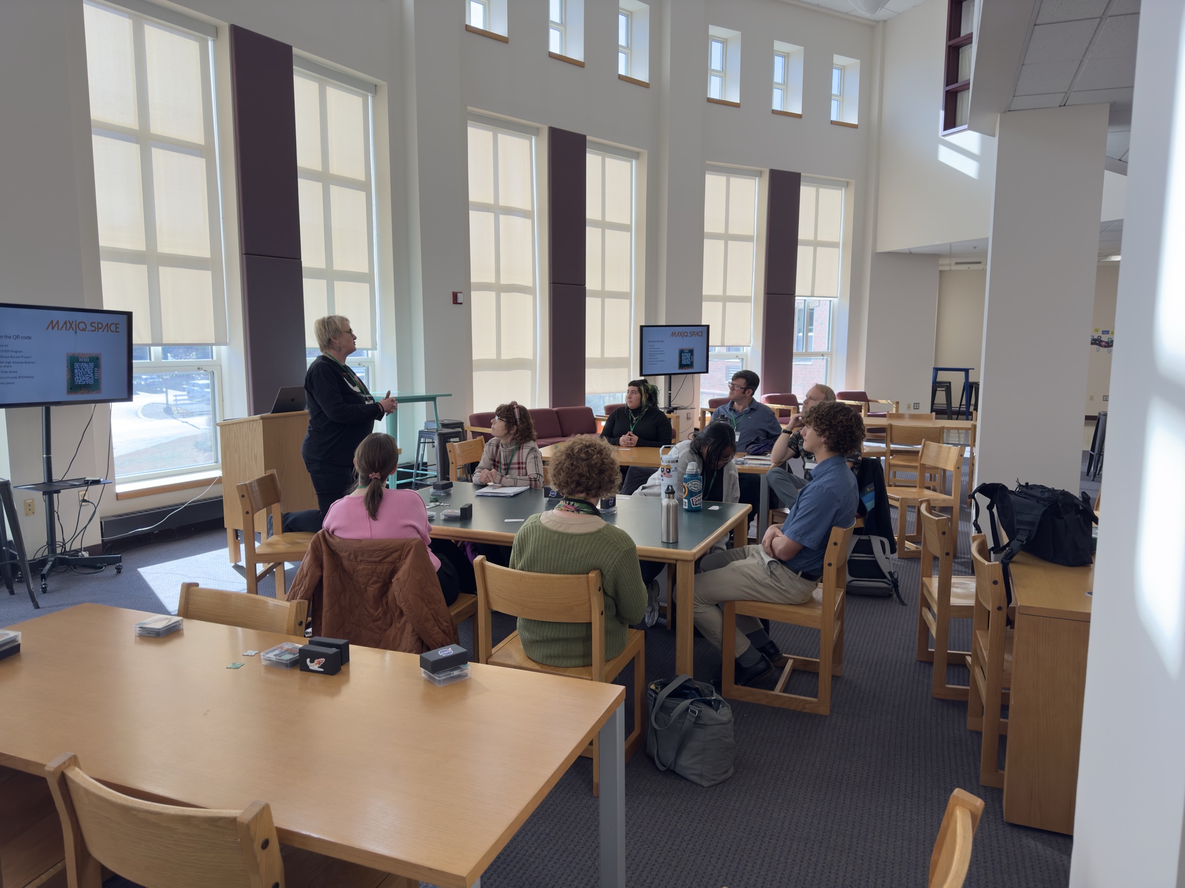 An educator leading a hands-on STEM workshop with participants gathered around a table